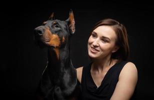 Portrait of a Doberman dog with a girl owner. photo