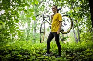 un joven se detuvo a descansar con su bicicleta en un parque público. foto