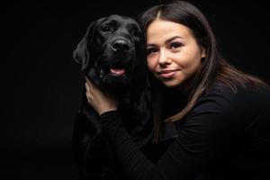 A girl holds a Labrador Retriever dog in her arms. photo