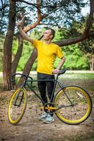 A young man taking a selfie with his Bicycle. photo