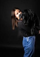 A girl holds a Labrador Retriever dog in her arms. photo