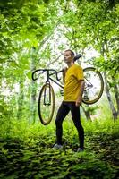 un joven se detuvo a descansar con su bicicleta en un parque público. foto