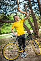 A young man taking a selfie with his Bicycle. photo