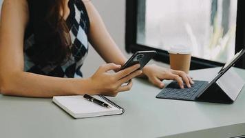 Geschäftsmann, der mit Smartphone und Laptop und digitalem Tablet-Computer im Büro mit digitalem Marketing arbeitet video