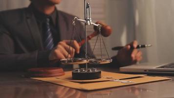 justice and law concept.Male judge in a courtroom on wooden table and Counselor or Male lawyer working in office. Legal law, advice and justice concept. video