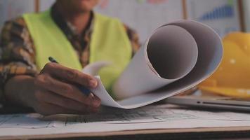 due colleghi che discutono di dati di lavoro e tablet, laptop con sul progetto architettonico in cantiere alla scrivania in ufficio video