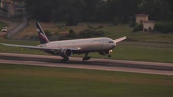 SOCHI, RUSSIA JULY 30, 2022 - Boeing 777 of Aeroflot landing and braking in Sochi airport at sunset. Airliner arrival. Tourism and travel concept video