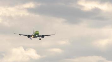 Unrecognizable jet plane landing approach, front view, slow motion. Tourism and aviation concept video