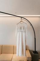 White gown or wedding dress hanging as a preparation for wedding. photo