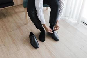 Business man getting ready by tying shoelaces. photo