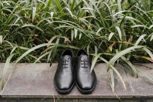 A pair of formal black gentlemen shoes laying on the ground, with negative space good for concept print. photo