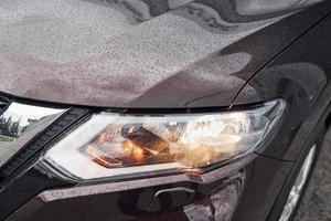 Front particle view of black modern automobile with headlights on photo