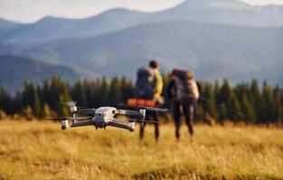 Drone flying near young travelers. Majestic Carpathian Mountains. Beautiful landscape of untouched nature