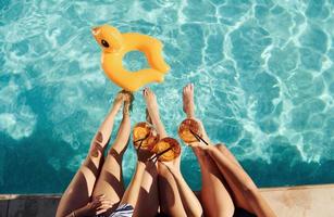 vista superior del grupo de jóvenes felices que se divierten en la piscina durante el día foto