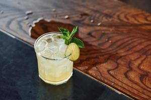 Green mint and yellow lime. Close up view of fresh summer cocktail on the wooden table photo