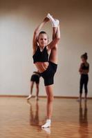 Group of female kids practicing athletic exercises together indoors photo