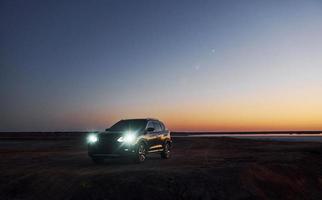 Distant view of modern black automobile that is on the coast photo