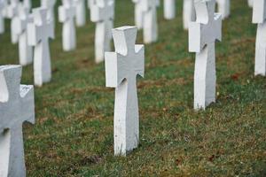 Cemetery with many of white memorial crosses of unnamed people. Conception of death photo
