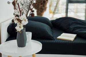 libro en la cama. interior y diseño de hermoso dormitorio moderno durante el día foto