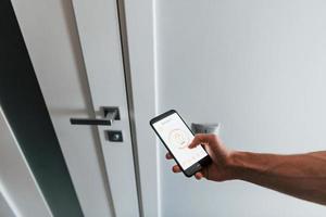 Close up view of man that is indoors controlling smart home technology photo