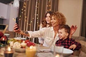 Happy family of mother, daughter and son is on the kitchen at evening time photo