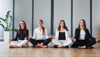 Group of adult women that in formal clothes is indoors in the office together photo