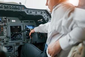 vista de cerca piloto en el trabajo en el avión de pasajeros. preparándose para el despegue foto