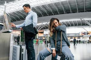 la mujer está cansada. pareja joven está en el aeropuerto juntos foto