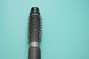 Electric hair dryer with a round brush. Coiled hair after drying. Hair loss. Rotating hair brush, styler, barber tool. photo