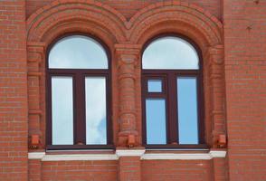 Facade element of a red brick building with two arched windows. Restoration of houses. Architecture. photo