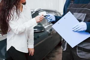 clienta recupera su auto en el servicio de lavado de autos foto