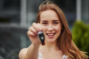 Portrait of cheerful blonde with keys of her brand new car photo