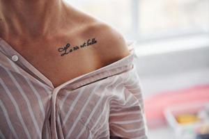 vista de cerca del tatuaje de mujer en camisa con rayas en el interior foto