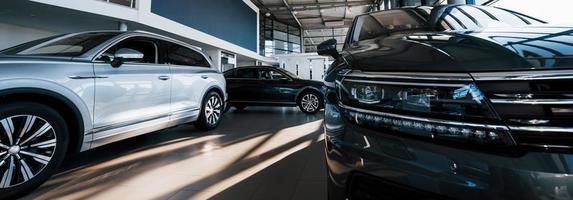 coches nuevos en la sala de exposición del concesionario. perfectamente pulido. iluminación natural foto