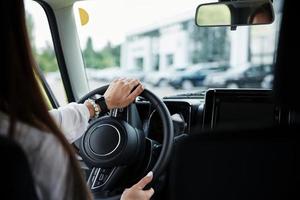 vista de partículas de la mujer que conduce un coche nuevo y moderno en la ciudad foto