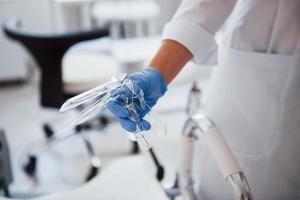 Close up view of female doctor hands that holds speculum instrument photo