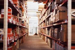 Storage room with pallet truck and many of objects at daytime photo