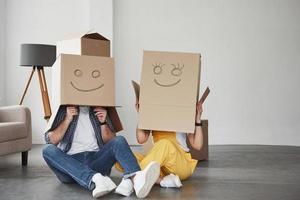 imágenes sonrientes en las cajas. pareja feliz juntos en su nueva casa. concepción de movimiento foto