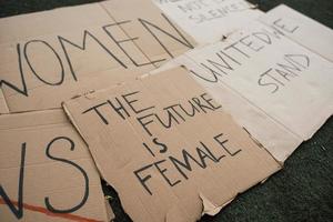 Handmade signs. Group of banners with different feminist quotes lying on the ground photo