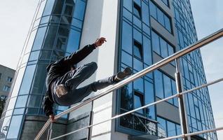 Young man doing parkour in the city at daytime. Conception of extreme sports photo