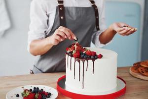 Close up view of woman that puts cherries on the sweet pie photo