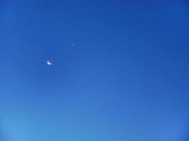 Blue sky with new moon, a crescent moon and star in the bright twilight sky of Jordan with copy space photo