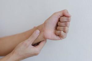 Closeup of hand with hand pain in palm isolated on gray wall background. photo