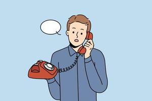 Stunned young man talking on landline phone. Amazed male with speech bubble above head speak on wired headset. Vector illustration.