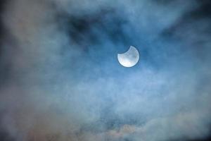 Image of a partial solar eclipse through veil clouds photo