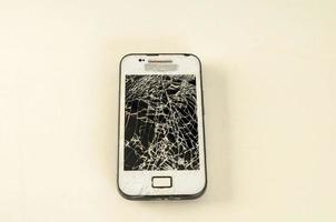 Broken cellphone on white background photo