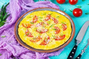 Omelette with tomatoes, herbs and grated cheese. Easy breakfast photo