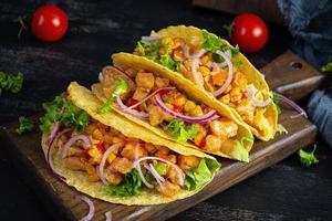 Mexican tacos with corn tortilla. Tortilla with chicken meat, corn, lettuce and onion photo