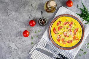 Omelette with tomatoes, herbs and grated cheese. Easy breakfast photo