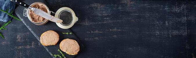 Sandwich with chicken liver pate on dark background. Top view photo